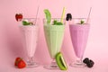 Tasty fresh milk shakes and ingredients on pink background Royalty Free Stock Photo