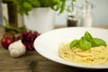 Tasty fresh pasta with garlic and basil on table