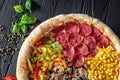 Tasty fresh pizza with four different pieces in one on wooden background. Top view of big pizza Royalty Free Stock Photo