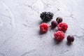 Tasty fresh ripe raspberry, blackberry, gooseberry and red currant berries, healthy food fruit on stone concrete background Royalty Free Stock Photo