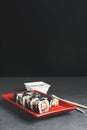 Tasty and fresh sushi set served in a red plate with wooden chopsticks. Close-up, selective focus on sushi. Royalty Free Stock Photo