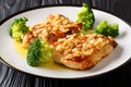 Tasty fried Amandine chicken fillet with almonds served with broccoli close-up on a plate. horizontal