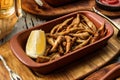 Tasty fried anchovies in cornmeal with lemon piece in wooden background, grilled small fish for beer, snacks Royalty Free Stock Photo