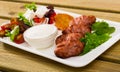 Tasty fried balkan kebapcheta served with salad of greens and brynza Royalty Free Stock Photo