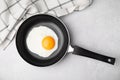 Tasty fried egg in pan on light grey table, flat lay Royalty Free Stock Photo