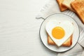Tasty fried egg in shape of heart with toasts on wooden table, flat lay. Space for text Royalty Free Stock Photo