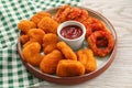 Tasty fried onion rings, chicken nuggets and ketchup on white wooden table Royalty Free Stock Photo