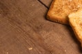 Tasty fried toast bread slices lie on a natural brown wooden background.