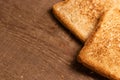 Tasty fried toast bread slices lie on a natural brown wooden background. Royalty Free Stock Photo