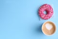 Tasty frosted donut and cup of coffee on light blue background, flat lay. Space for text Royalty Free Stock Photo
