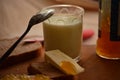 Glass of fresh milk ,spoon with apricot jam and butter .