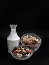 Tasty Gadola, Cereal and Nuts in Glass Bowl served with Almond Milk in Dark Background
