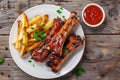 Tasty glazed bbq pork ribs served with golden french fries and dipping sauce Royalty Free Stock Photo