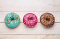 Tasty glazed donuts on white wooden table, flat lay