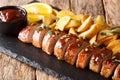 Tasty glazed pork tenderloin with potato wedges close-up on a slate board. horizontal