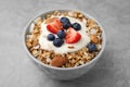 Tasty granola, yogurt and fresh berries in bowl on light grey table, closeup. Healthy breakfast Royalty Free Stock Photo