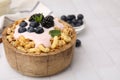 Tasty granola, yogurt and fresh berries in bowl on white tiled table, closeup with space for text. Healthy breakfast Royalty Free Stock Photo