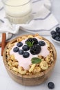 Tasty granola, yogurt and fresh berries in bowl on white table. Healthy breakfast Royalty Free Stock Photo