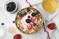 Tasty granola, yogurt and fresh berries served on white tiled table, flat lay. Healthy breakfast Royalty Free Stock Photo