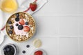 Tasty granola, yogurt and fresh berries served on white tiled table, flat lay with space for text. Healthy breakfast Royalty Free Stock Photo