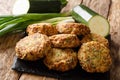 Tasty greek zucchini balls with feta cheese with ingredients close-up on a slate board. horizontal Royalty Free Stock Photo