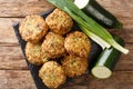 Tasty greek zucchini balls with feta cheese with ingredients close-up on a slate board. Horizontal top view Royalty Free Stock Photo