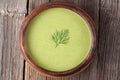 Tasty green cream vegetarian soup meal in wooden