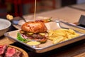 Tasty grilled burger with beef,cheese,bacon and sauce on wooden table with french fries and beer Royalty Free Stock Photo