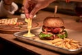 Tasty grilled burger with beef,cheese,bacon and sauce on wooden table with french fries and beer Royalty Free Stock Photo