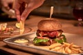 Tasty grilled burger with beef,cheese,bacon and sauce on wooden table with french fries and beer Royalty Free Stock Photo