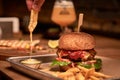 Tasty grilled burger with beef,cheese,bacon and sauce on wooden table with french fries and beer Royalty Free Stock Photo