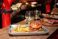 Tasty grilled burger with beef,cheese,bacon and sauce on wooden table with french fries and beer Royalty Free Stock Photo