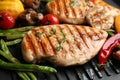 Tasty grilled chicken fillets with vegetables on frying pan, closeup Royalty Free Stock Photo