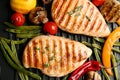 Tasty grilled chicken fillets with vegetables on frying pan, flat lay Royalty Free Stock Photo