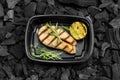 Tasty grilled fish with lemon and rosemary in to go box on coal Royalty Free Stock Photo