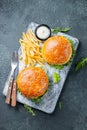 Tasty grilled home made burger with beef, tomato, cheese, cucumber and lettuce on a dark stone background. Top view. fast food and Royalty Free Stock Photo