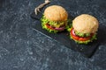 Tasty grilled homemade burgers with beef, tomato, cheese on stone background. Copy space Royalty Free Stock Photo