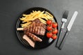 Tasty grilled steak served on black table, flat lay Royalty Free Stock Photo