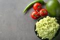 Tasty guacamole with ingredients on grey textured background Royalty Free Stock Photo