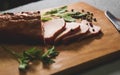 Tasty ham lying on the wooden panel plank. Meat with green leaves spinach. Food photo with pepper spices