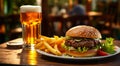 Tasty hamburger, french fries and glass of light beer on the table. Royalty Free Stock Photo