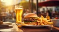 Tasty hamburger, french fries and glass of light beer on the table. Royalty Free Stock Photo