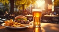 Tasty hamburger, french fries and glass of light beer on the table. Royalty Free Stock Photo