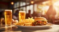 Tasty hamburger, french fries and two glasses of light beer on the table. Royalty Free Stock Photo