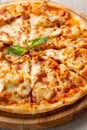 Tasty hawaiian pizza with chicken and pineapple on wooden cutting board