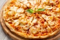 Tasty hawaiian pizza with chicken and pineapple on wooden cutting board