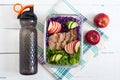 Tasty healthy lunch of vegetables, baked turkey and a bottle of water. Salad of red cabbage, spinach, apples, fresh cucumbers with Royalty Free Stock Photo