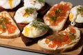 Tasty and healthy toasts: poached eggs on rye bread and toasts with butter and red salmon caviar