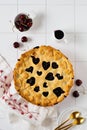 Tasty homemade cherry pie with hearts on a light beautiful ceramic background. Valentines Day baked goods. Top view