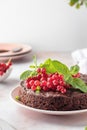 Tasty homemade chocolate cake brownie decorated with red currant berries and mint on white marble table close up, text Royalty Free Stock Photo